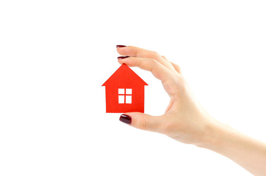 The hand holds the red house. House in hands. Close up. Isolated on a white background