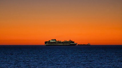 Obraz premium Sunset Cruise Ship at Cottesloe Beach during summer