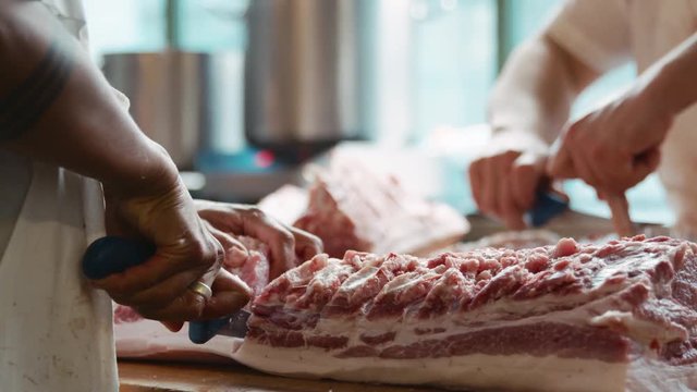 Two butchers preparing meat at a butcher's shop, mid section