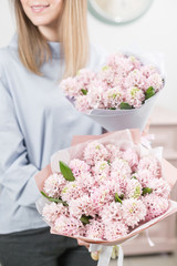 Two flowers bouquet. Sunny spring morning. Young happy woman holding a beautiful bunch of pink hyacinths in her hands. Present for a smiles girl.