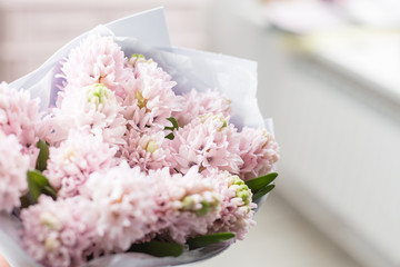 Flowers bouquet. Sunny spring morning. Young happy woman holding a beautiful bunch of pink hyacinths in her hands. Present for a smiles girl.
