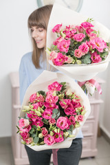 Two flowers bouquet. Sunny spring morning. Young happy woman holding a beautiful bunch of pink eustoma or Lisianthus in her hands. Present for a smiles girl.