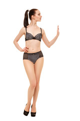 Fototapeta premium The girl stops someone with a gesture of the hand. Young beautiful girl in black lingerie isolated on white background