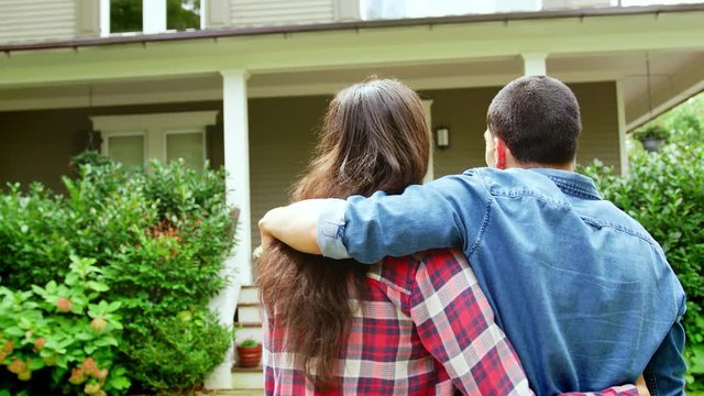 Rear View Of Loving Couple Looking At House