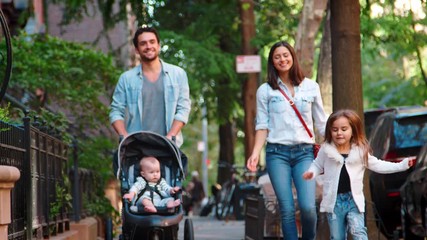 Happy young family walking in a Brooklyn street - Powered by Adobe