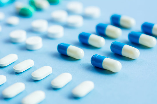 Medical tablets on light blue background