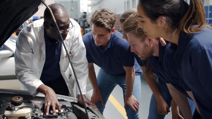 Tutor Explaining How Engine Works To Group Of Apprentices