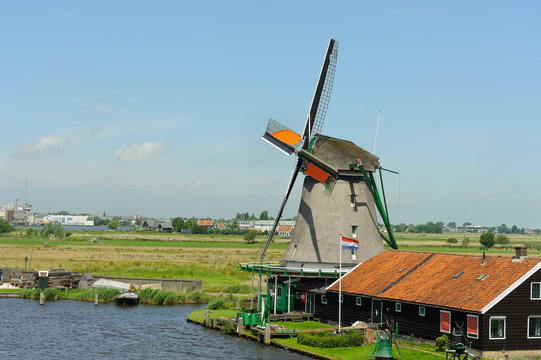 Traditional dutch windmill near the canal in summer day. Netherlands