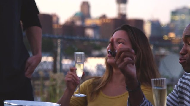 Friends talking around a table on a Brooklyn rooftop