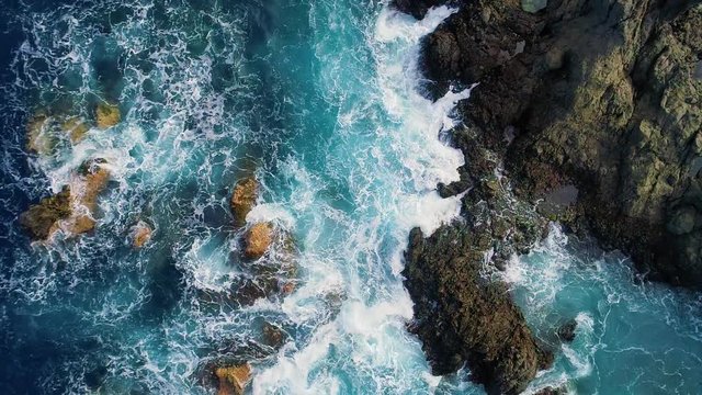 slow motion top down view of waves and clifs