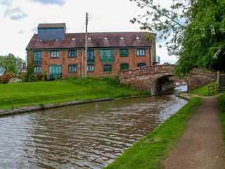 Fototapeta na wymiar Old bridge with towpath and an old storehouse on the Shropshire Union canal in Market Drayton, England