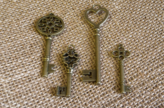 Four bronze ancient keys on burlap.
