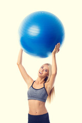 Young smiling woman in sportswear with fitball
