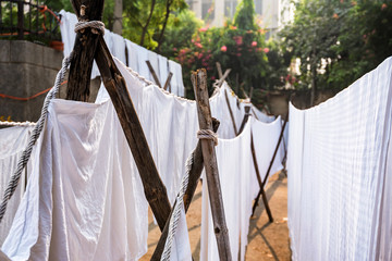 White sheets hang on ropes in Indian street