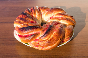 Sweet bun with jam on wooden table
