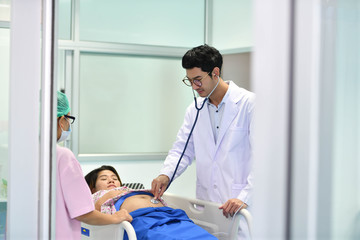 Fototapeta premium Doctor, nurse examining pregnant woman with stethoscope at maternity ward