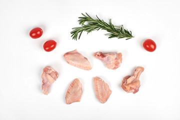 Raw chicken wings, tomatoes and rosemary isolated on white background