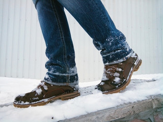 Cyclone. Winter brown shoes in the snow. Walk on the snow. Danger of slipping on ice. Side view.