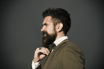 Man with beard and mustache on dark grey background.