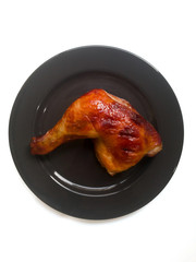 chicken leg quarters with crispy golden brown skin on black plate