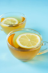 Two cups of tea with lemon. Blue background. Pastel colors. Minimalism. Place for text
