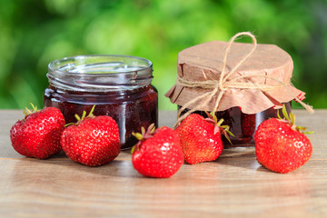 Traditional homemade strawberry jam in a jars, decorated with fresh strawberries
