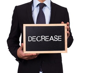 Businessman holding mini blackboard with DECREASE message