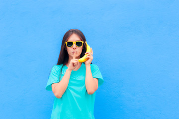 Funny Girl with Sunglasses and Banana Phone on Blue Background © nicoletaionescu