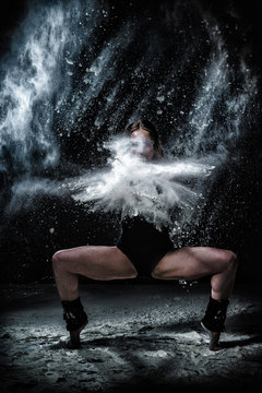 Girl dansing with flour on black background