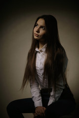 Naklejka premium Portrait of a young adult woman in a white shirt thoughtful