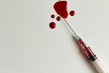Syringe with blood and blood splatters closeup and isolated on white background