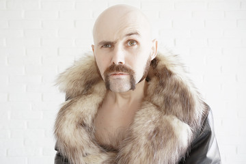 brutal mustachioed man in a fur coat
