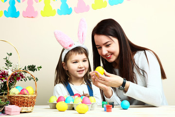 Obraz na płótnie Canvas Mother and little daughter coloring Easter eggs