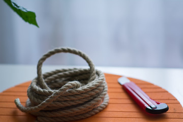 Coarse rope roll and a knife with red handle against
