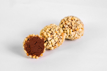 Cut chocolate candies with nuts on white background