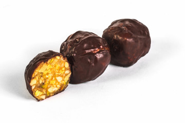 Cut chocolate candies with nuts on white background
