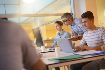 Obraz premium Nauczyciel z uczniami na stażu w klasie informatyki