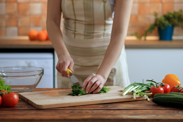Woman cutting greens on the kitchen