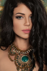 Perfect Young Woman with Long Curly Hair and Green Necklace. Female Face Closeup