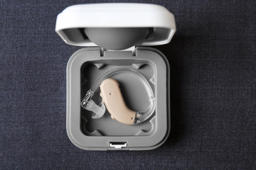 Hearing aid in box on fabric, top view