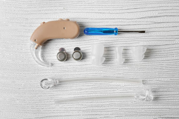 Composition with hearing aid and accessories on light background