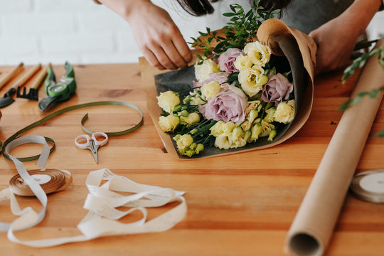 woman florist collects bouquet decorates different flowers