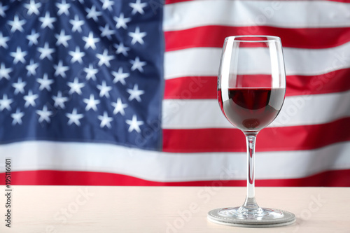 Glass of wine on table against American flag background