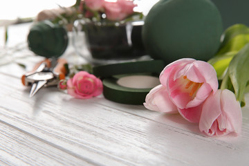 Florist equipment with flowers on wooden table