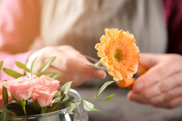 Crédence de cuisine en verre imprimé Fleuriste Female florist making beautiful bouquet at table, closeup