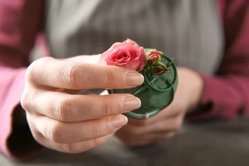 Photo sur Plexiglas Fleuriste Female florist using sponge for work at table, closeup