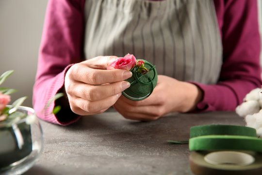 Female florist using sponge for work at table, closeup