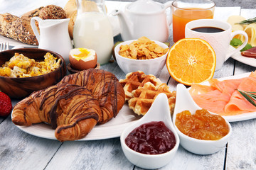 breakfast on table with waffles, croissants, coffe and juice