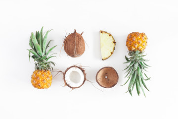 Fruit background. Pineapples and coconuts on white background. Summer fruits. Flat lay, top view