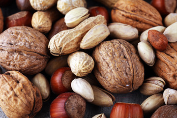 mixed nuts on grey background. Healthy food and snack. Walnut, pecan, almonds, hazelnuts and cashews.